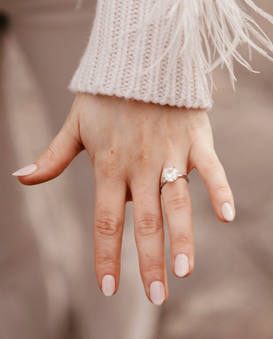 A diamond solitaire engagement ring in warm natural light